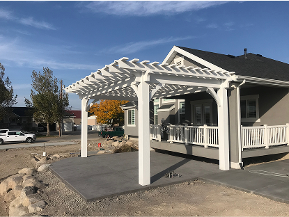 A white vinyl pergola is attached to the back of a contemporary gray house