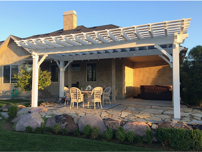 A bright white vinyl pergola covers a circular dining set on a flagstone patio