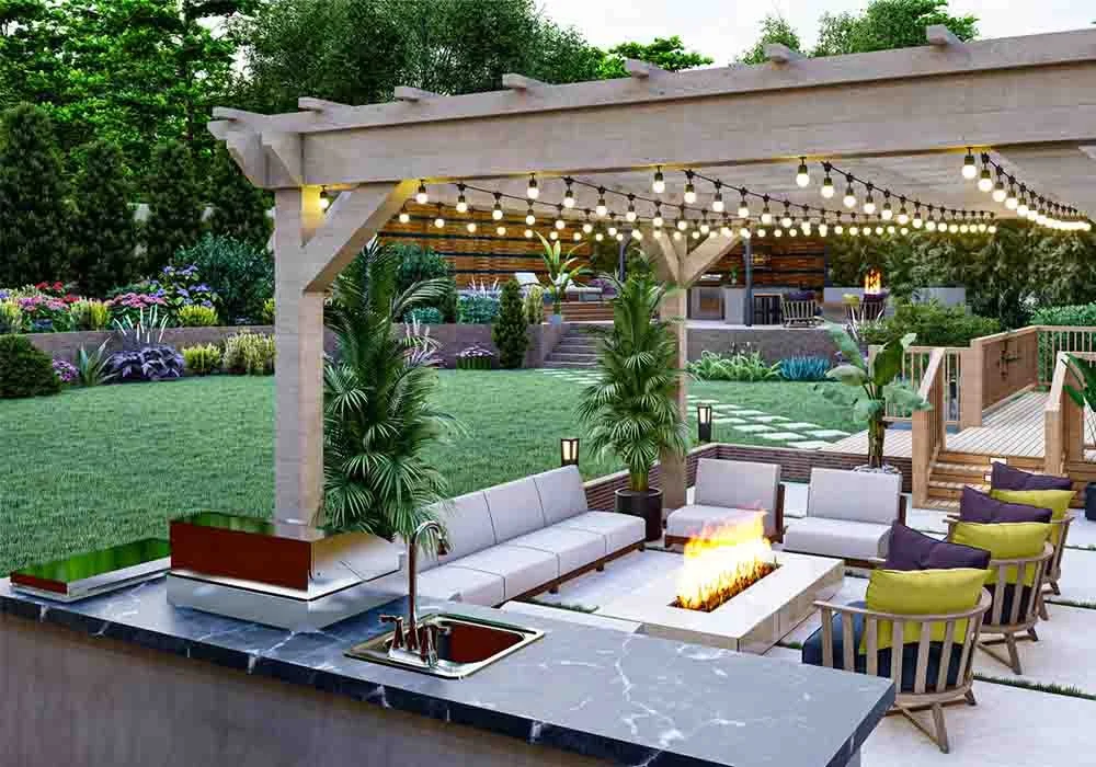 A large light wood pergola with string lights covers an outdoor kitchen and a sunken seating area with a fire pit