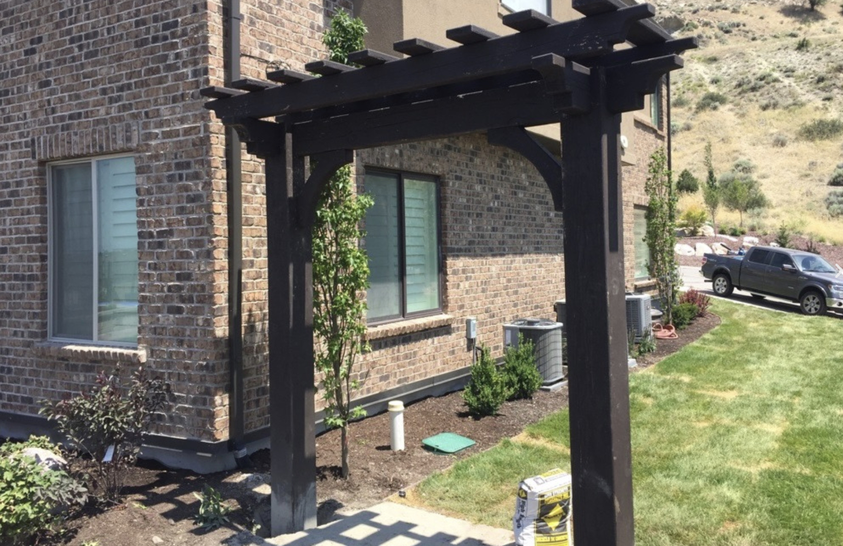 Dark wood trellis frame placed near a home&rsquo;s entry, highlighting the purpose of trellis for garden charm and vertical plant support
