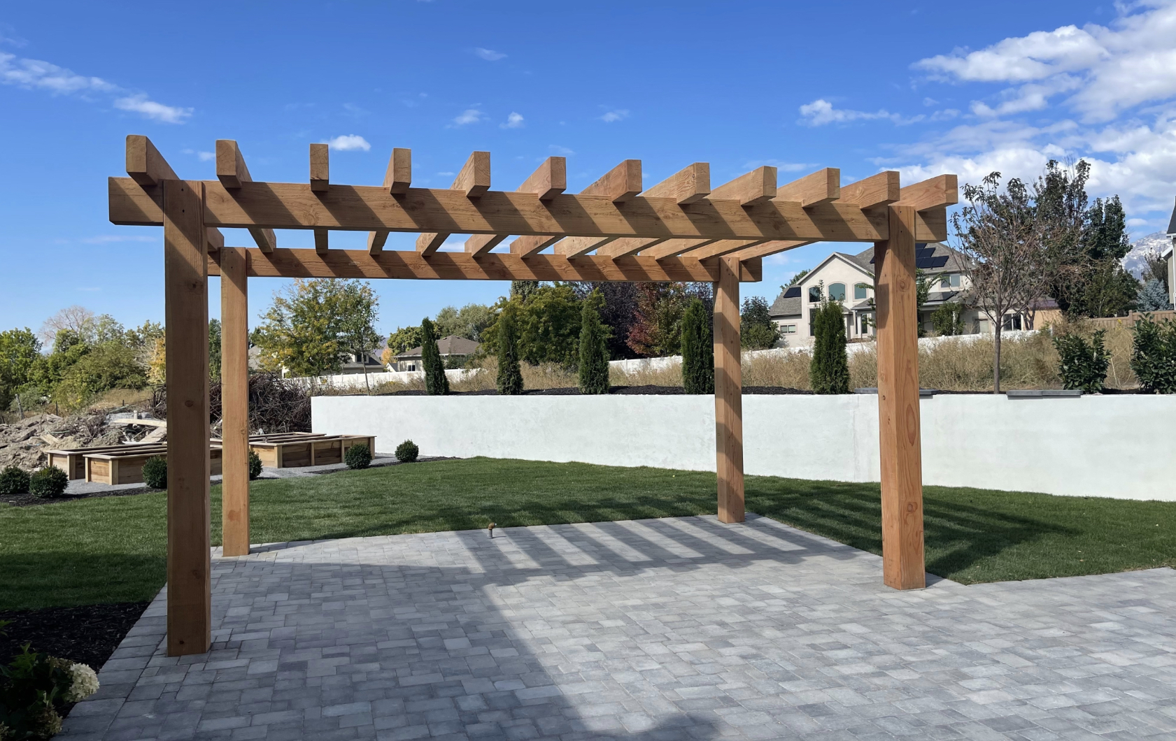Timber Frame DIY Pergola Kit on Patio A timber frame DIY pergola kit installed on a stone patio, creating a stylish outdoor space with shade and modern backyard appeal.