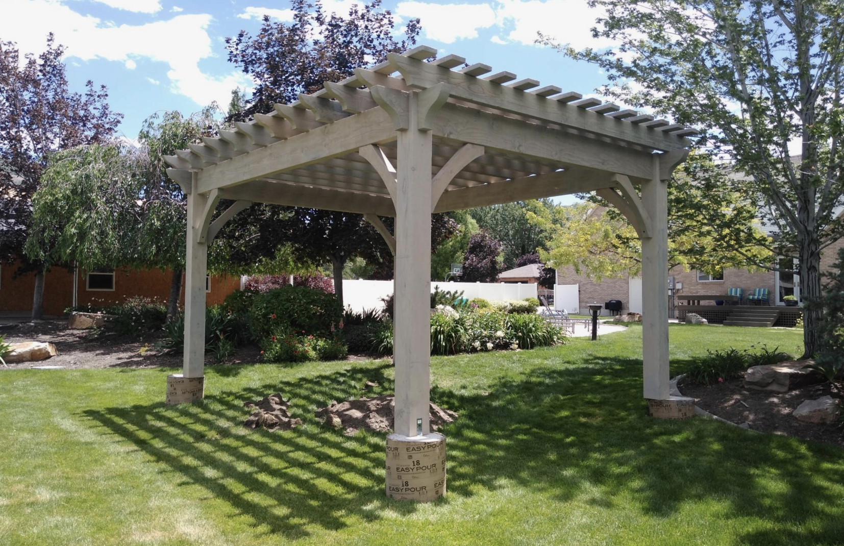 Backyard timber pergola on concrete footings, braced posts, stable design addressing are freestanding pergolas safe.
