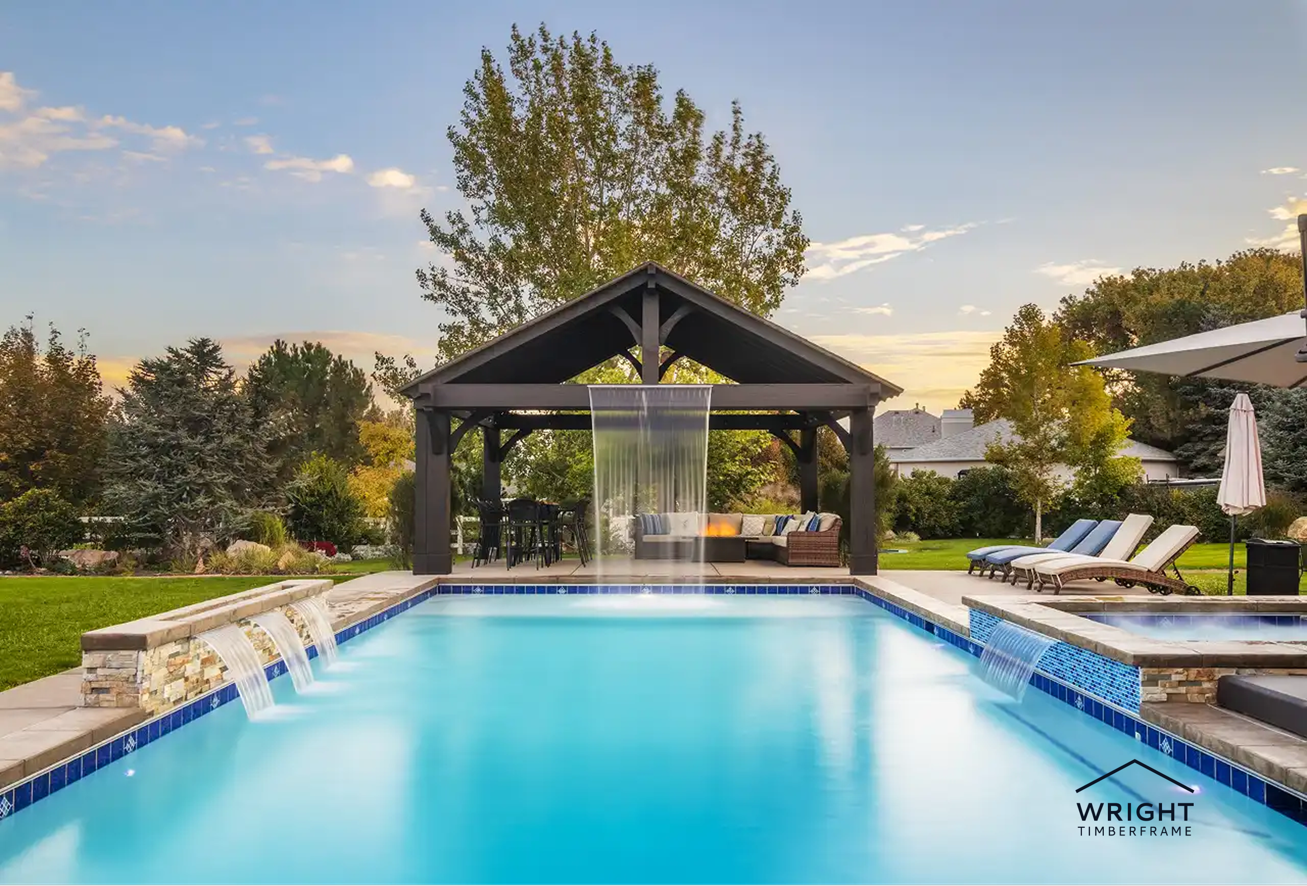 Poolside timber pavilion with waterfall feature and lounge seating, showcasing a luxury backyard pavilion kit in landscaped yard.
