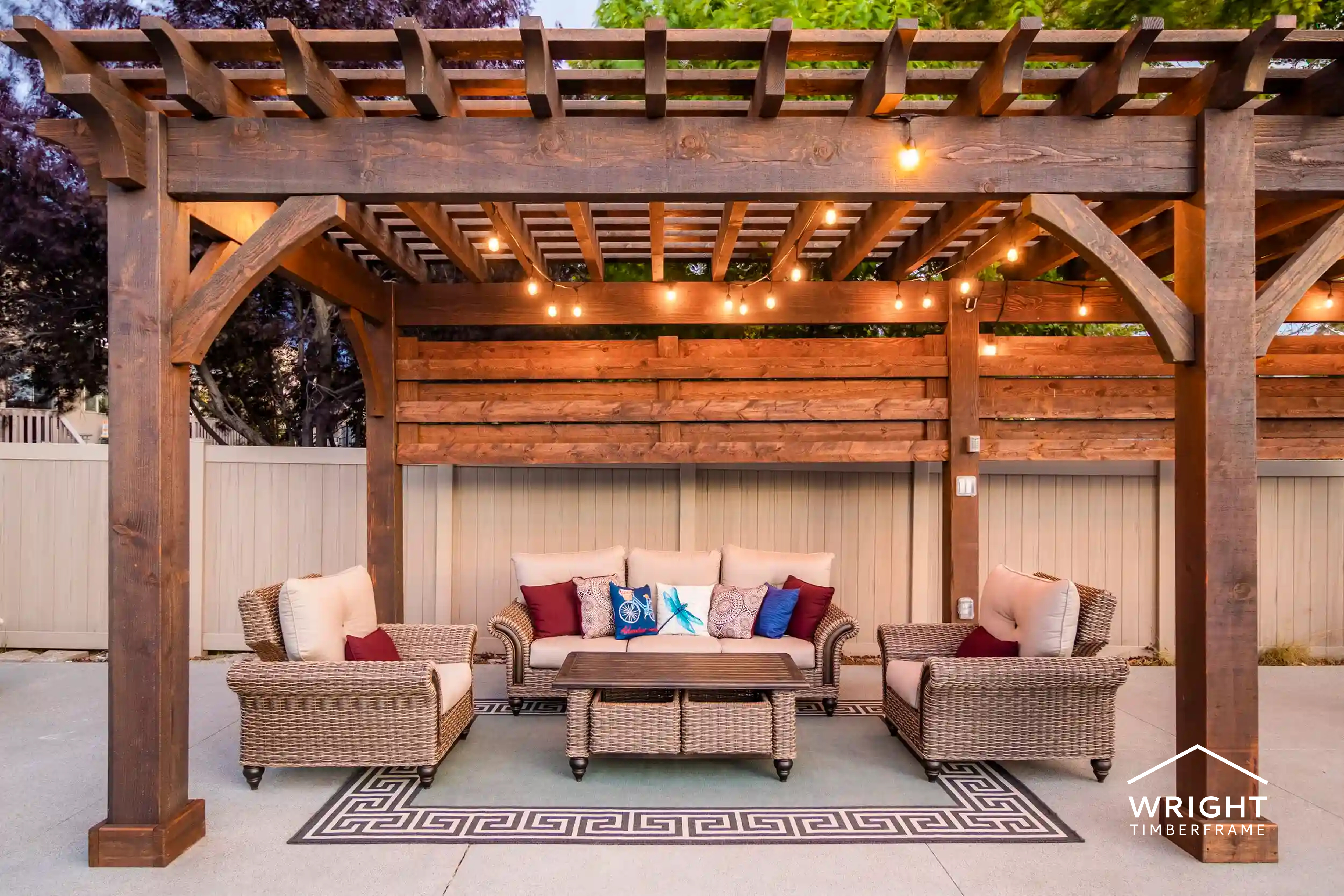 Timber pergola with string lights over cozy outdoor seating, showcasing stylish outdoor living additions for backyard spaces.