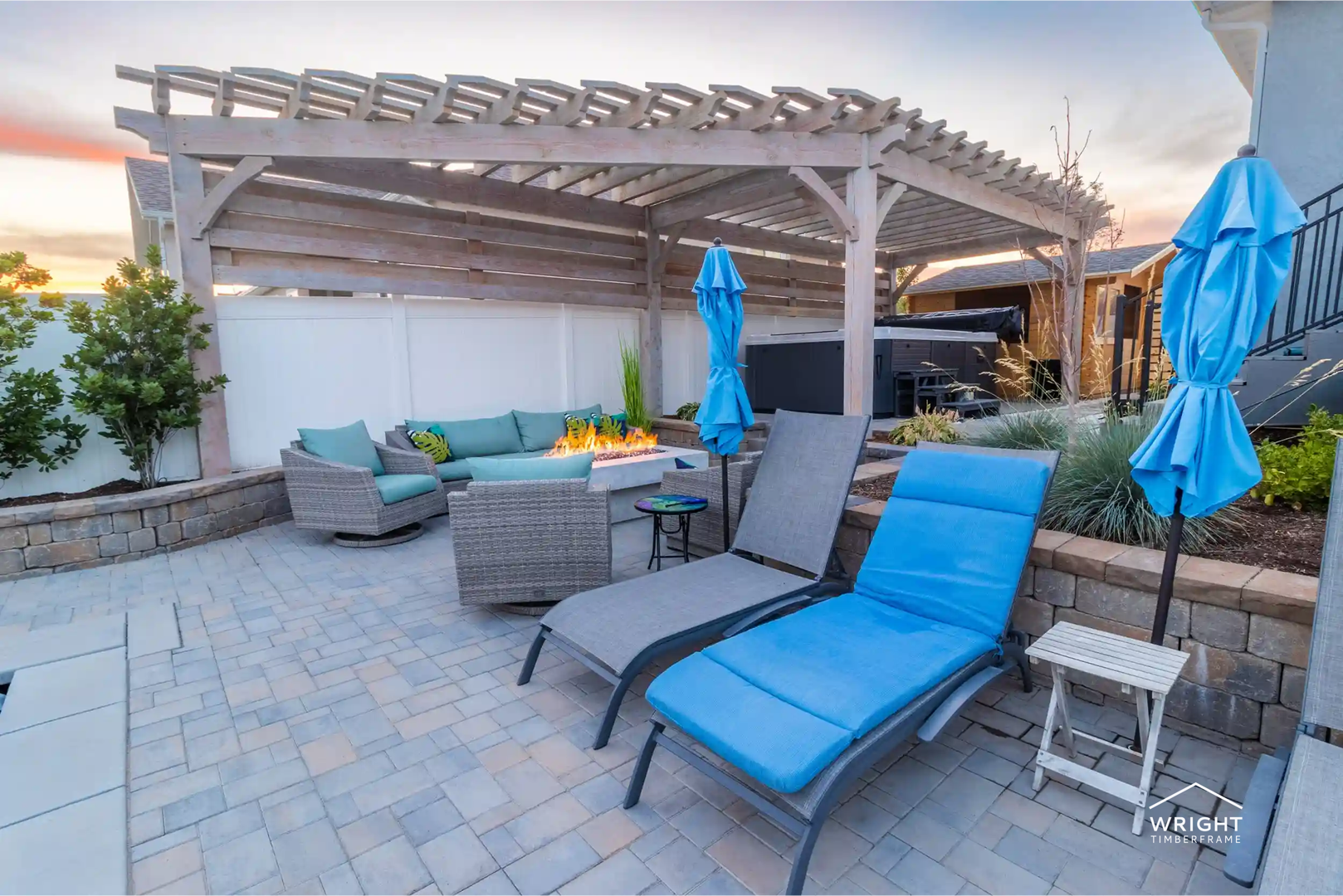 Custom Pergolas vs Prefab: Which Is Right for You? Backyard patio with a custom pergola, seating, and fire feature, illustrating the design, durability, and lifestyle benefits of custom pergolas vs. prefab options.