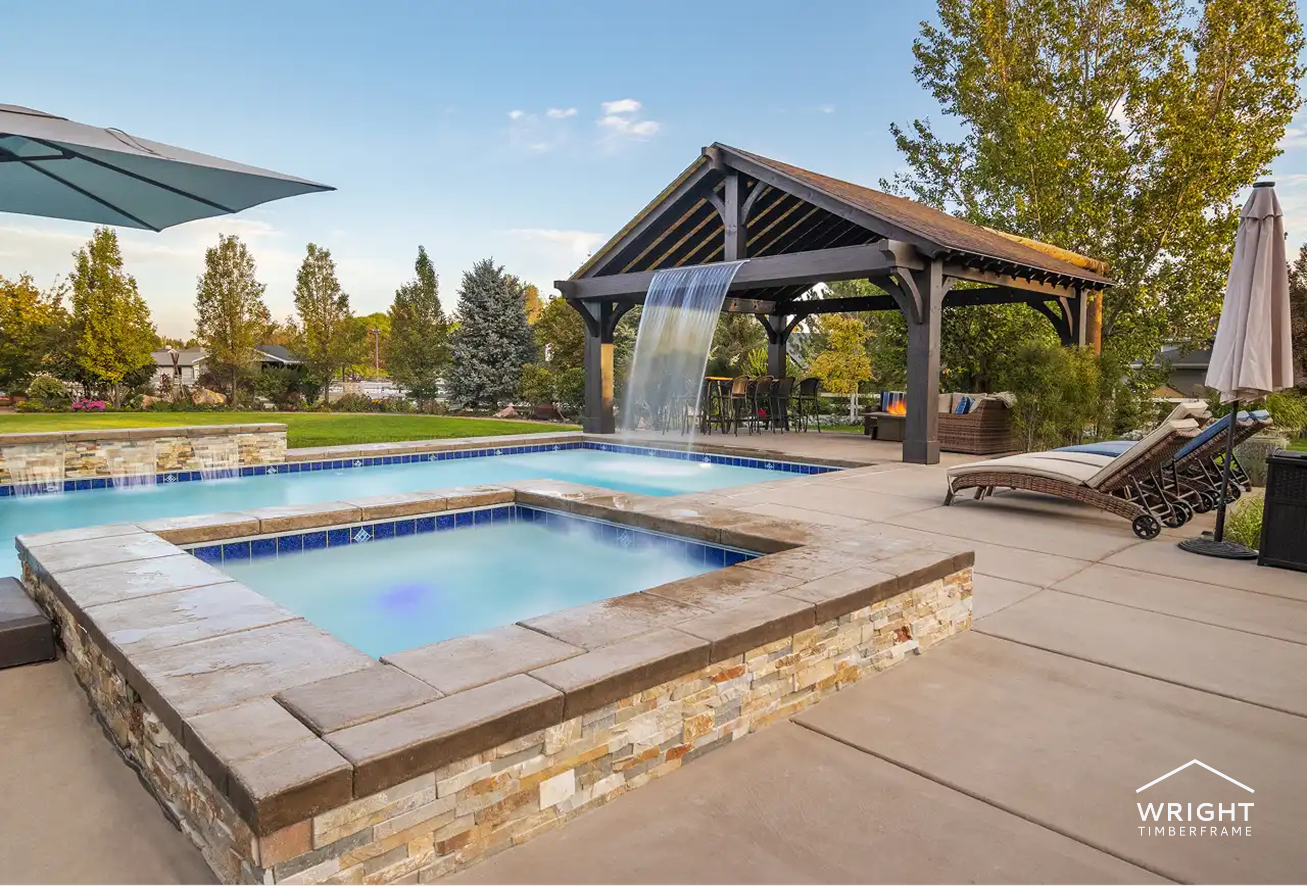 Poolside pavilion with waterfall feature, lounge seating, and landscaped outdoor area for relaxation.