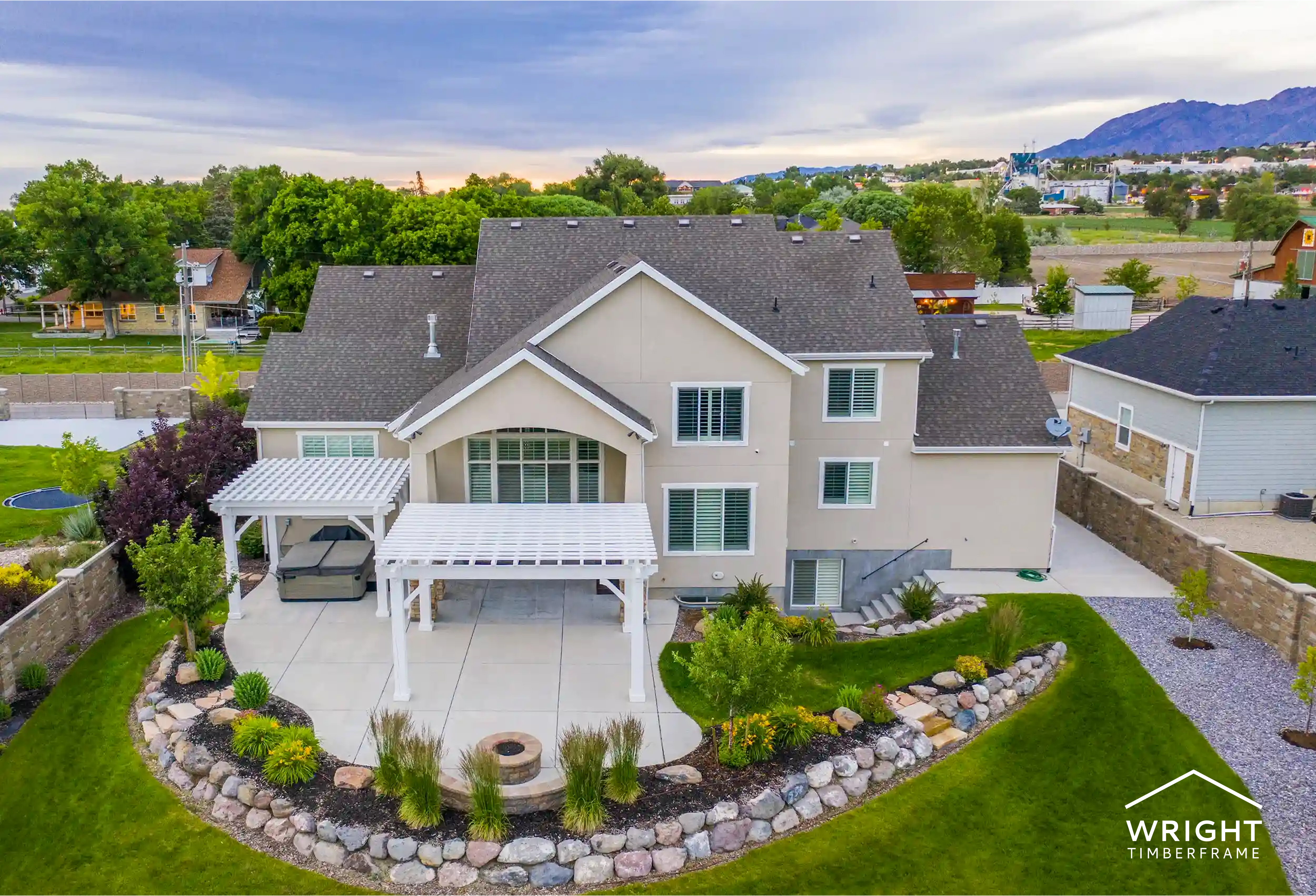 Custom Pergolas vs Prefab for Backyard Living Aerial view of a home with custom pergolas over a patio, comparing design, fit, and durability in custom pergolas vs prefab options.