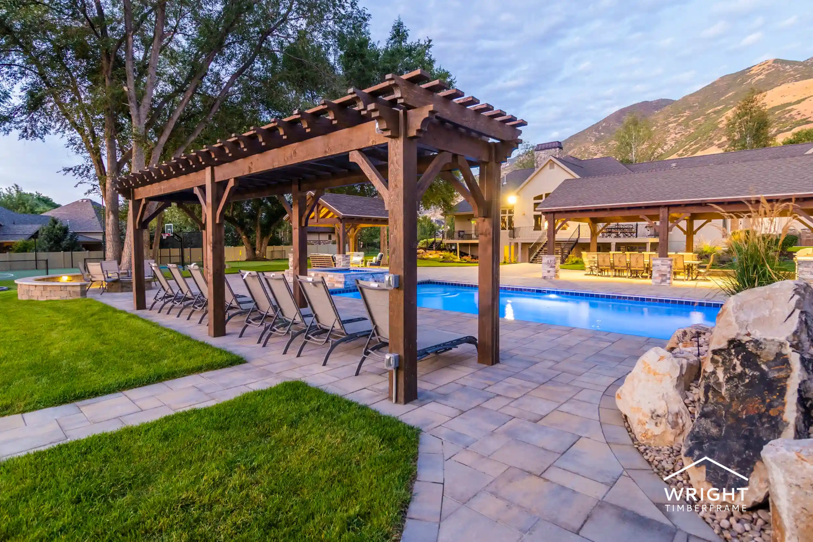 Large timber pergola beside backyard pool with lounge chairs, showcasing craftsmanship from top pergola builders.