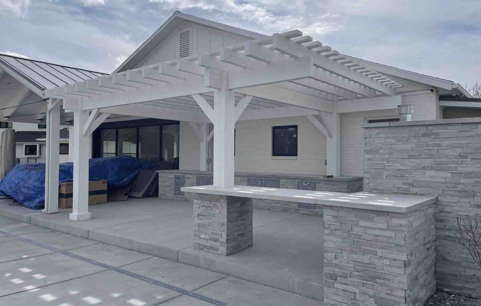 Modern Outdoor Kitchen with Pergola Design Contemporary backyard setup featuring a stone outdoor kitchen with pergola, showing how outdoor kitchens with pergolas create stylish, functional entertaining spaces.