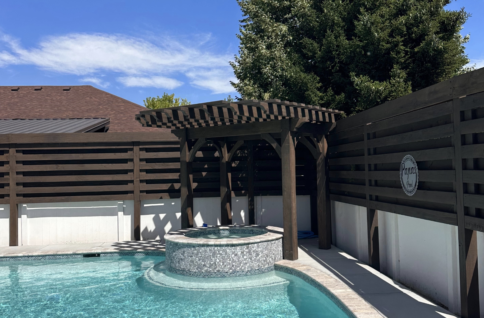 Custom timber trellis and pergola over hot tub in Utah garden.