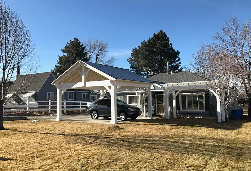 Custom timber frame pavilion with a gabled roof and car shelter in Murray, Utah.