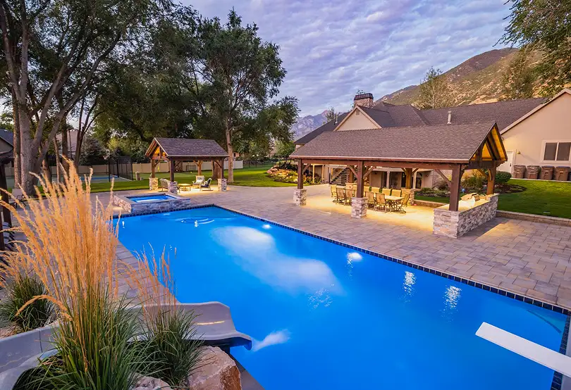 Custom timber frame pavilion and pergola overlooking swimming pool in Murray, Utah.
